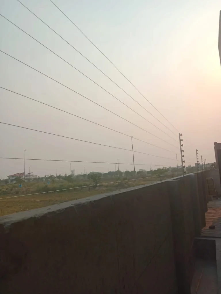 Multi-strand electric fence along a boundary wall